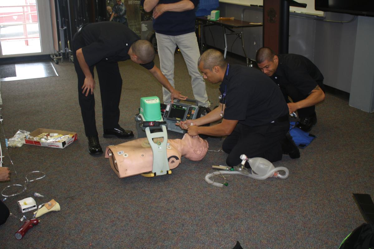 Fire fighter recruits learn to intubate a patient in a classroom