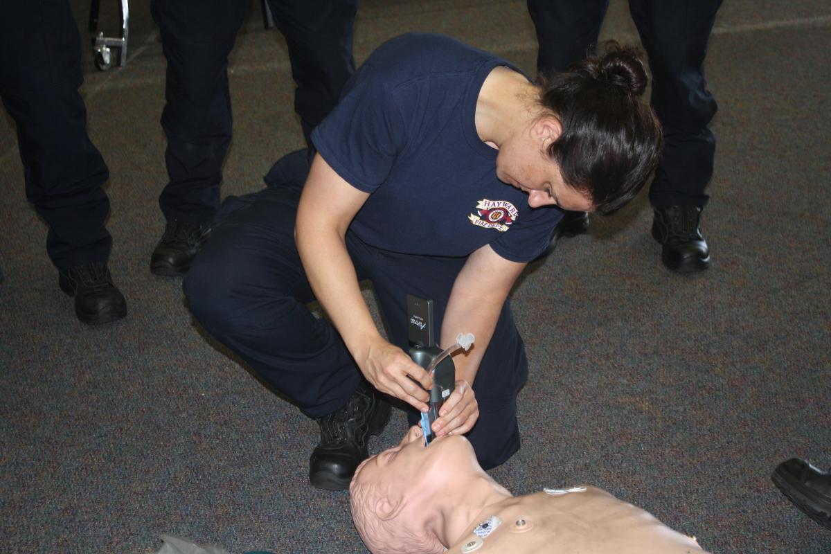 Close up of a fire fighter recruit practicing how to intubate a patient in a classroom