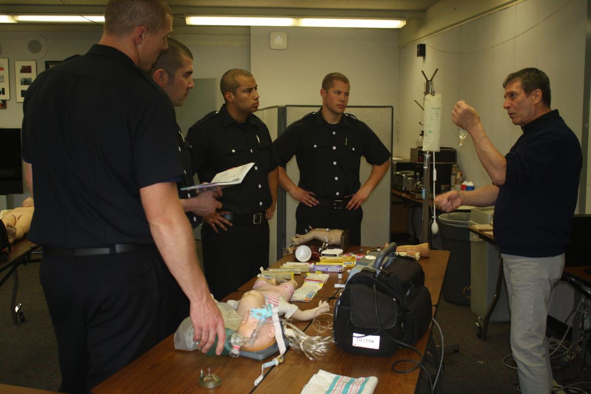 Fire fighter recruits listen to EMT director Bob Negri as he talks about IVs