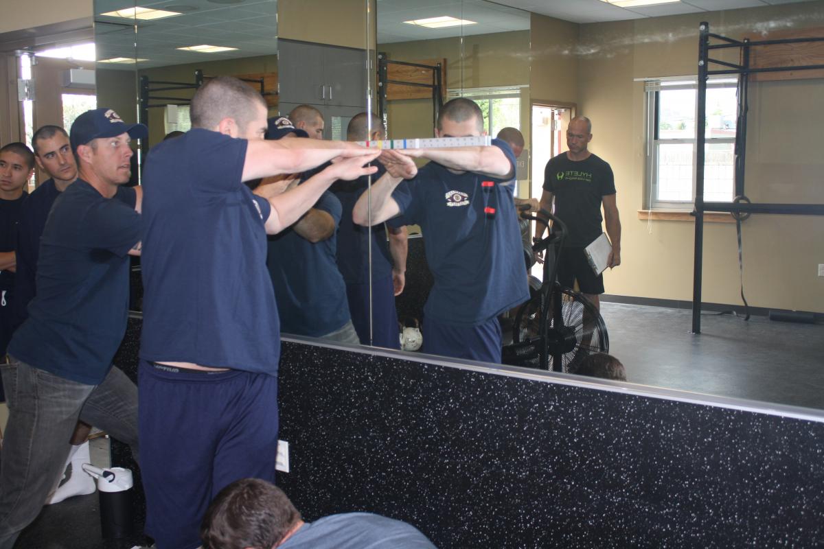 Fire fighter recruits working on fitness challenges in a classroom with Fire Fighters