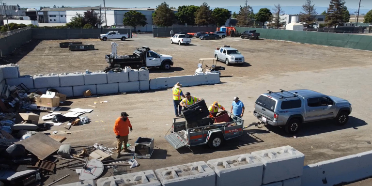 Photo of Disposal Day of workers in safety vests unloading things from a truck.