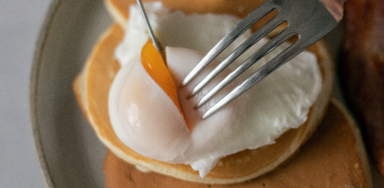 Pancake, egg, and fork on a plate
