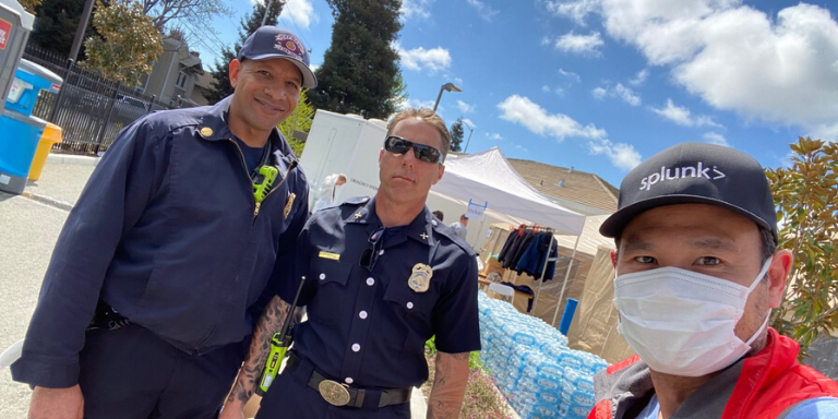 A volunteer wearing a mask standing with two Hayward Fire personnel