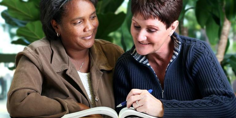 A tutor and learner read a book together