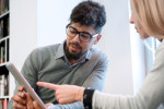 A tutor helping a learner use a tablet