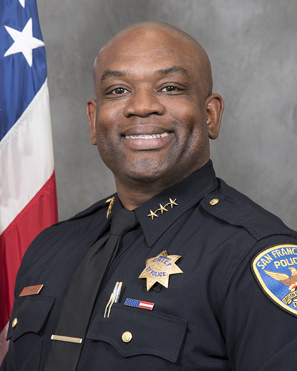 New Police Chief Toney Chaplin smiling next to the American Flag