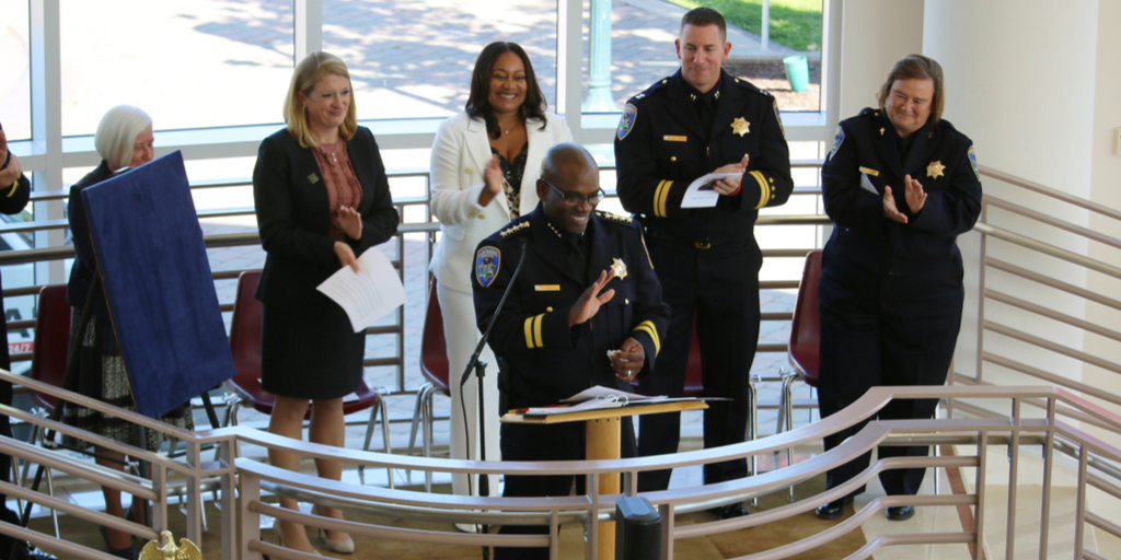 Chief Chaplin smiling at a podium during his swearing in ceremony