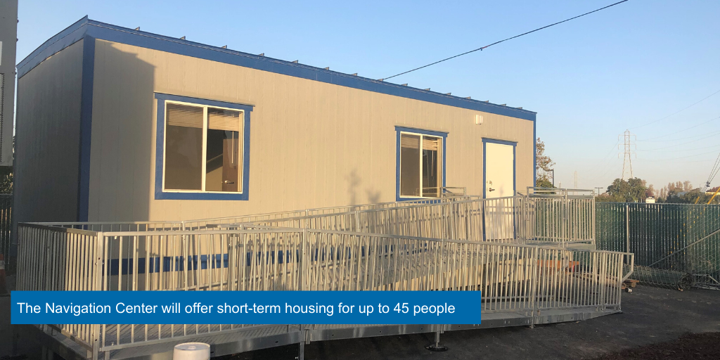 A blue and grey portable building with a wheelchair ramp