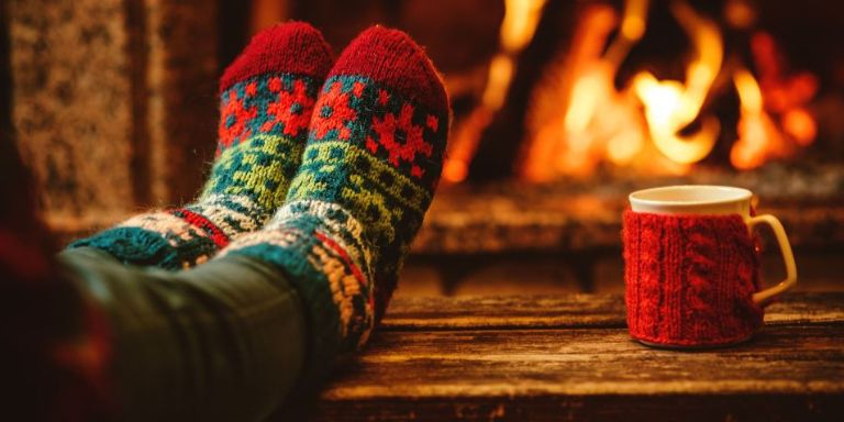 A person warming their feet by the fire