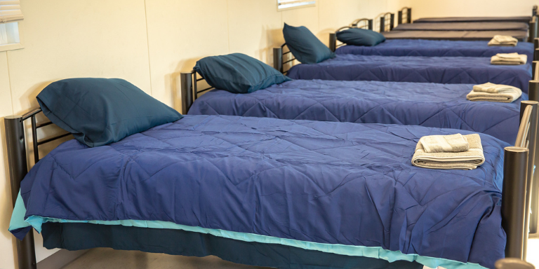 a row of blue beds lined up at the Navigation Center