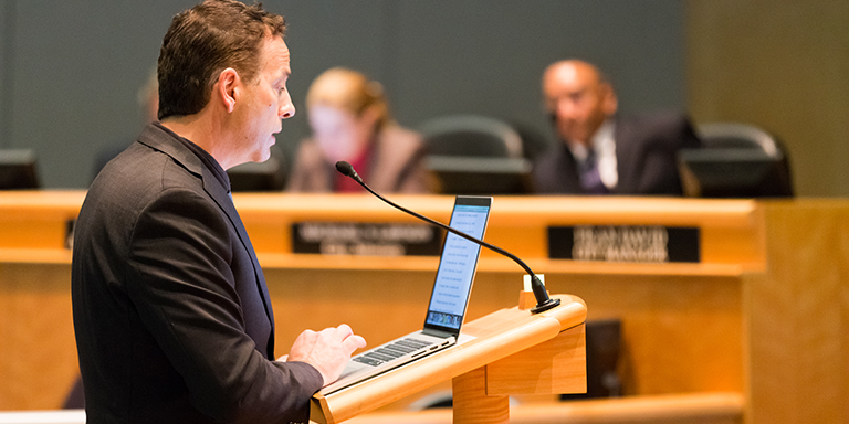 Man speaking at a city council meeting