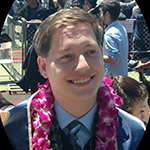 Austin Smith wearing a blue suit and pink lei