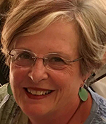 Patti Crotti smiling wearing green earrings