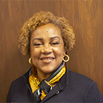 Dr. Stacy Thompson wearing a grey sweater and yellow scarf