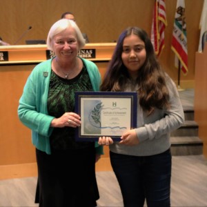 Young girl in a gray sweater standing next to Mayor Halliday