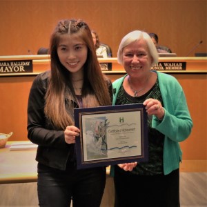 Young woman in a black coat standing with Mayor Halliday