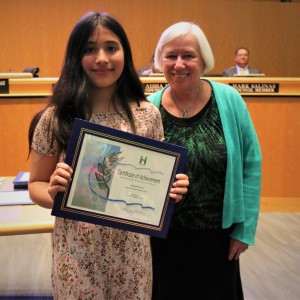 Young girl in a floral dress standing with Mayor Halliday