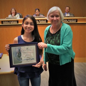 Young girl in a dark blue blouse standing with Mayor Halliday