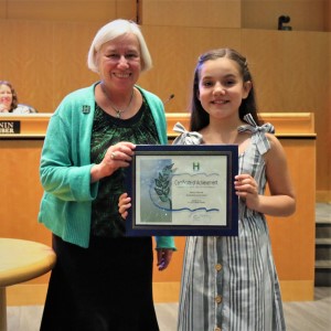 Young girl in a striped dress standing with Mayor Halliday