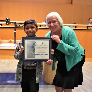 Little boy in a gray sweater with Mayor Halliday