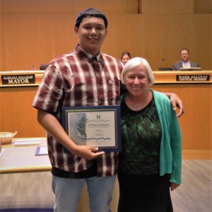 Young man with a brown and white checkered shirt standing with Mayor Halliday