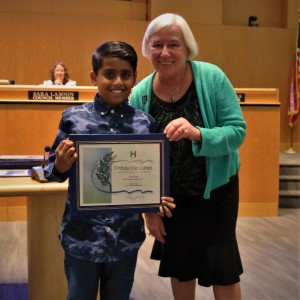 Young boy in a navy and lavender shirt standing with mayor Halliday 