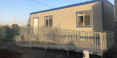 A blue and grey portable housing unit at the navigation center