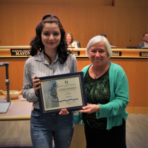 Young woman in a white and blue striped blouse standing with mayor Halliday