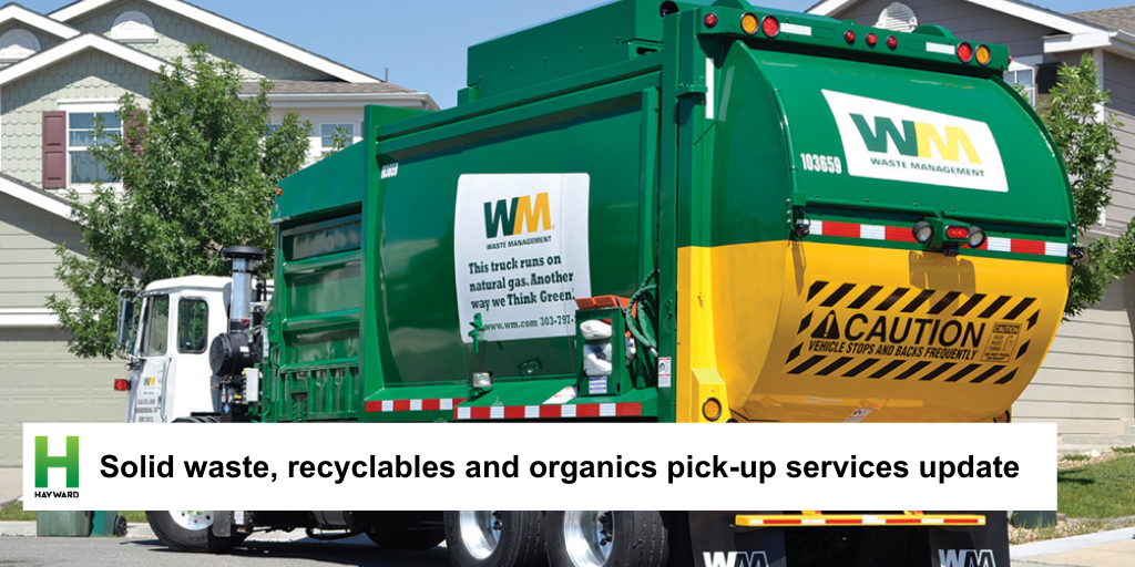 Waste management truck picking up trash cans