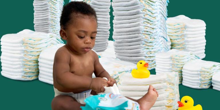 A baby, some rubber ducks, and several stacks of diapers