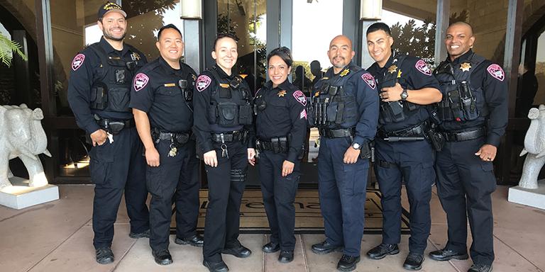 Police officers smiling and standing in front of a building