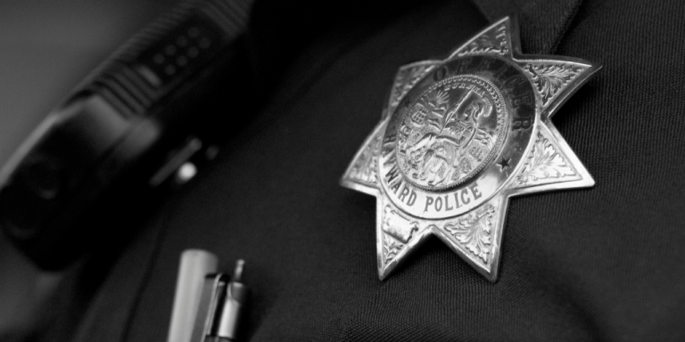 black and white close-up photo of a police badge 