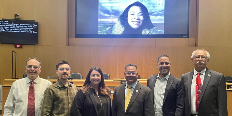 Full City Council from left: Councilmember Dan Goldstein, Councilmember George Syrop, Councilmember Julie Roche, Mayor Mark Salinas, newly appoint Councilmember Ray Bonilla, Councilmember Francisco Zermeño, Mayor Pro Tempore Angela Andrews picture on screen behind Councilmembers