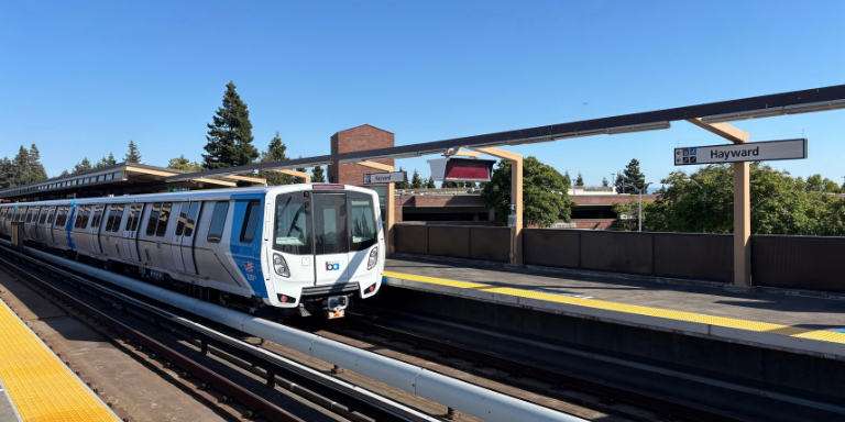 BART train leaving the Hayward BART station on a sunny, clear day