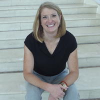 City Manager Kelly McAdoo sitting on steps smiling